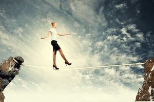 Image of pretty businesswoman balancing on rope