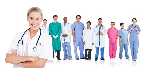 Smiling doctor standing in front of her medical team in line on white background