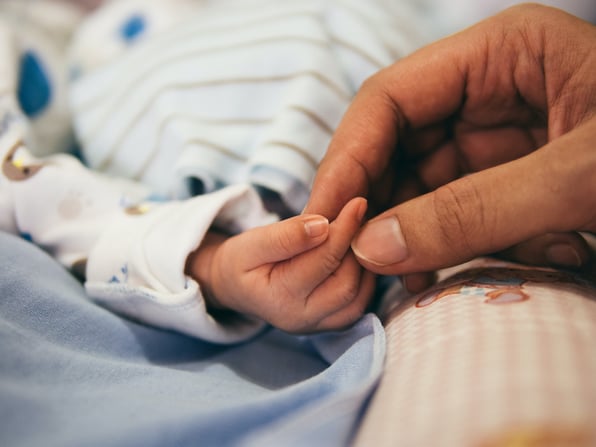 image of a parents holding a baby's hand